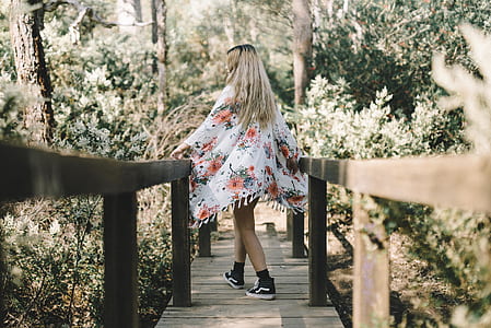 woman walking along wooden bridge thumbnail