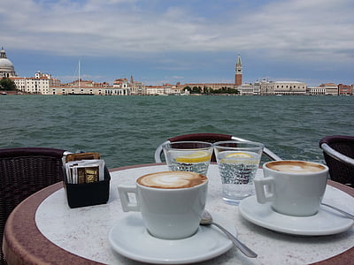 two ceramic coffee cups on table near body of water thumbnail