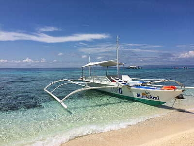 white and green boat on shore under blue sky during daytime thumbnail