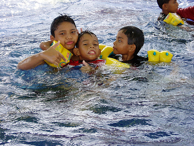 three boys floating on body of water thumbnail