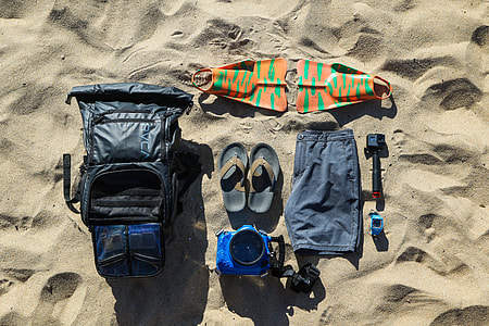 flatlay photo of swim gears on shoreline thumbnail