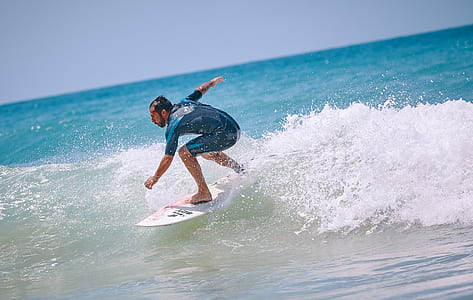 man surfing on sea at daytime thumbnail