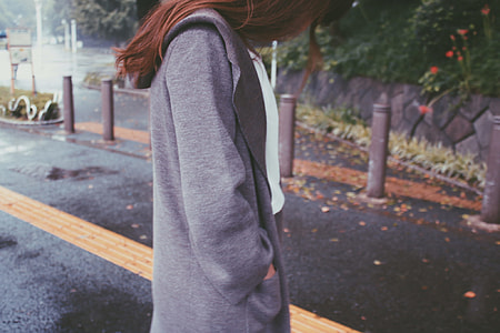blonde haired woman on gray jacket looking down in the middle of the road thumbnail