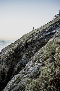 man on stony mountain under blue skies thumbnail
