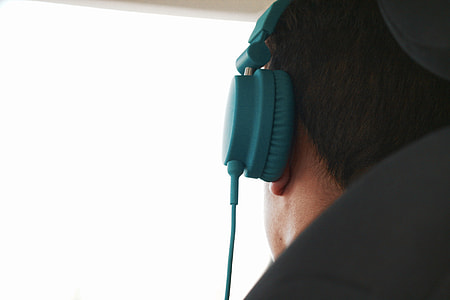 person wearing blue full-sized corded headset thumbnail