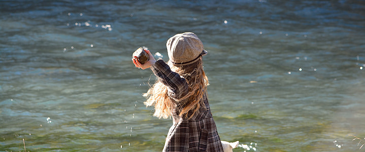 girl wearing black and gray plaid dress near body of water thumbnail