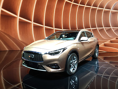 beige Infiniti SUV parked on black floor tile thumbnail