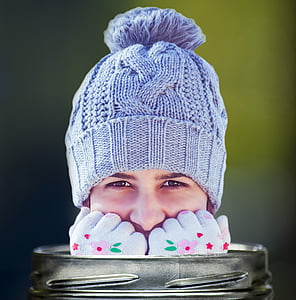 person wearing blue crochet bobble cap with head out of jar thumbnail