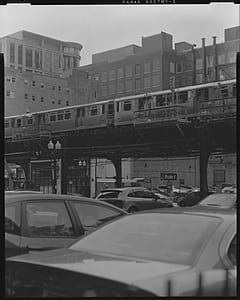 grayscale photography of vehicles under train thumbnail