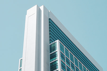 low-angle photography of white concrete framed curtain-wall high-rise building under blue sky thumbnail