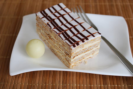 white and black chocolate cake on white ceramic plate beside gray stainless steel fork thumbnail