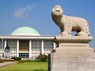 foo dog statue near white and green building thumbnail