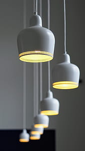 line of white pendant lamps with yellow bulbs thumbnail