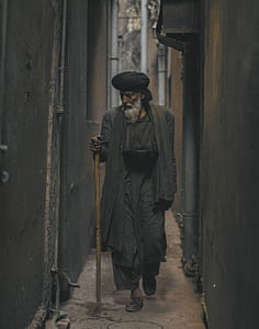 Photo of an Old Man Walking in the Alley thumbnail