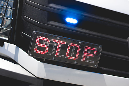 Police Flashing Light and STOP Sign on Car thumbnail