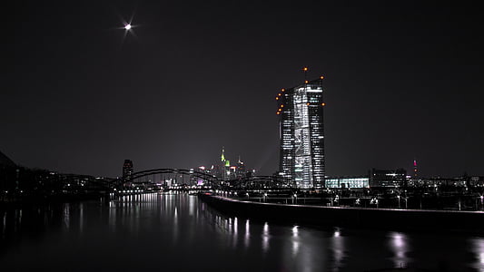 grayscale photo of city near large body of water during nighttime thumbnail