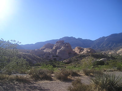 rock formation near green grass under blue and white sky thumbnail