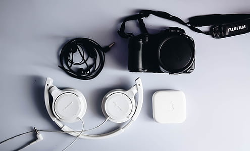 white corded headphones near black camera thumbnail