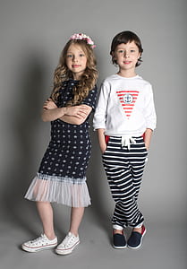 two girls standing beside gray wall thumbnail
