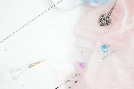 silver-colored heart pendant near glass bottle thumbnail