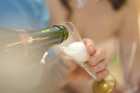 selective focus photography of person pouring champagne on clear glass flute thumbnail