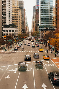 vehicles travelling asphalt road near high rise building thumbnail