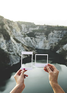 person holding two white papers thumbnail