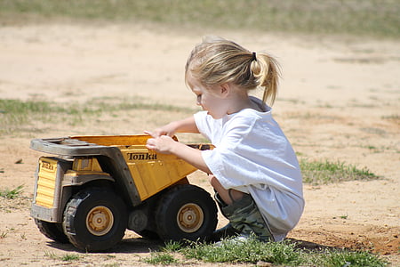 girl holding yellow and black Tonka drumptruck toy thumbnail