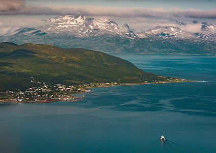 Aerial View Photography of Snow Covered Mountain Beside Ocean thumbnail