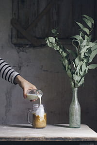 person holding clear glass bottle thumbnail