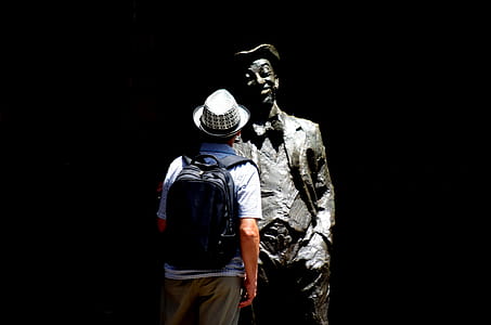 Man Standing in Front of Statue Photo thumbnail