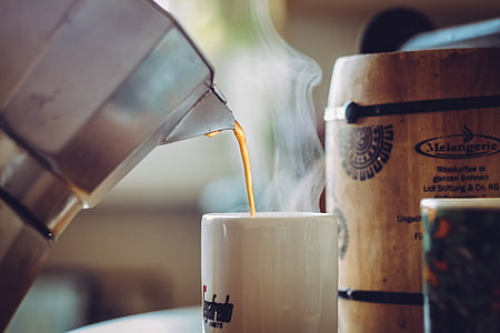 gray moka pot filling coffee in white mug thumbnail