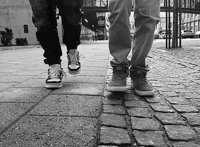 grayscale photography of two human feet on pavement surface thumbnail