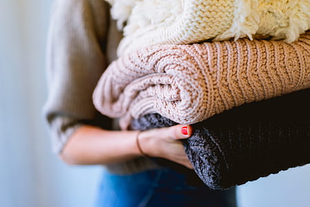 closeup photo of person carrying knitted cloths thumbnail