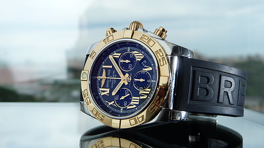 round blue and gold-colored chronograph watch with black strap thumbnail
