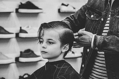 grayscale photo of boy being hair trimmied thumbnail