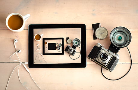 black iPad beside mug and DSLR camera thumbnail