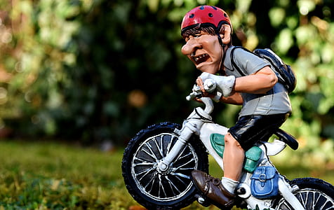 man riding motorcycle figurine in focus photography at daytime thumbnail