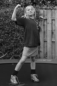 grayscale photo of girl standing near plant thumbnail