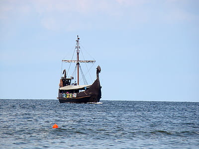 brown schooner on body of water during daytime thumbnail