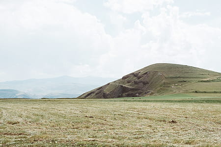 landscape photo of grass filled ground near mountain thumbnail