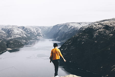 person in orange long-sleeved shirt and black pants thumbnail