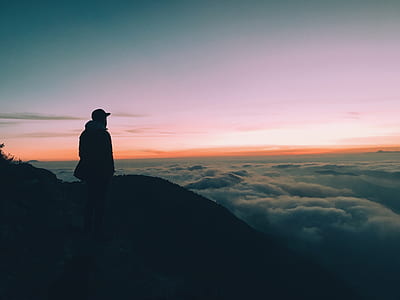 man standing on mountain top watching sea of clouds thumbnail