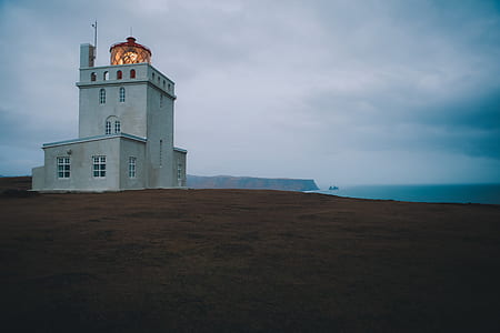 white building on green barren land thumbnail