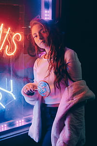 woman leaning on glass wall during nighttime thumbnail