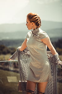 woman standing wearing grey cap-sleeved mini dress near glass fence thumbnail