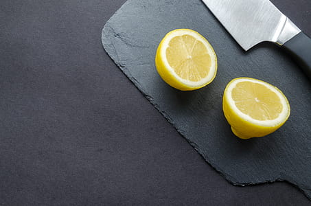 Sliced Lemon Beside Knife on Top of Black Surface thumbnail