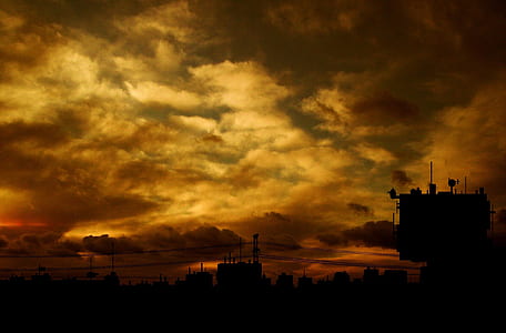 silhouette photo of city under cloudy sky thumbnail