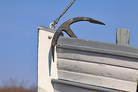 black boat anchor on white boat photography during daytime thumbnail