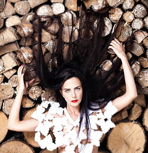Woman Lying Down on Bunch of Logs thumbnail